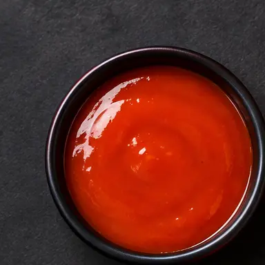Buffalo sauce in a black bowl